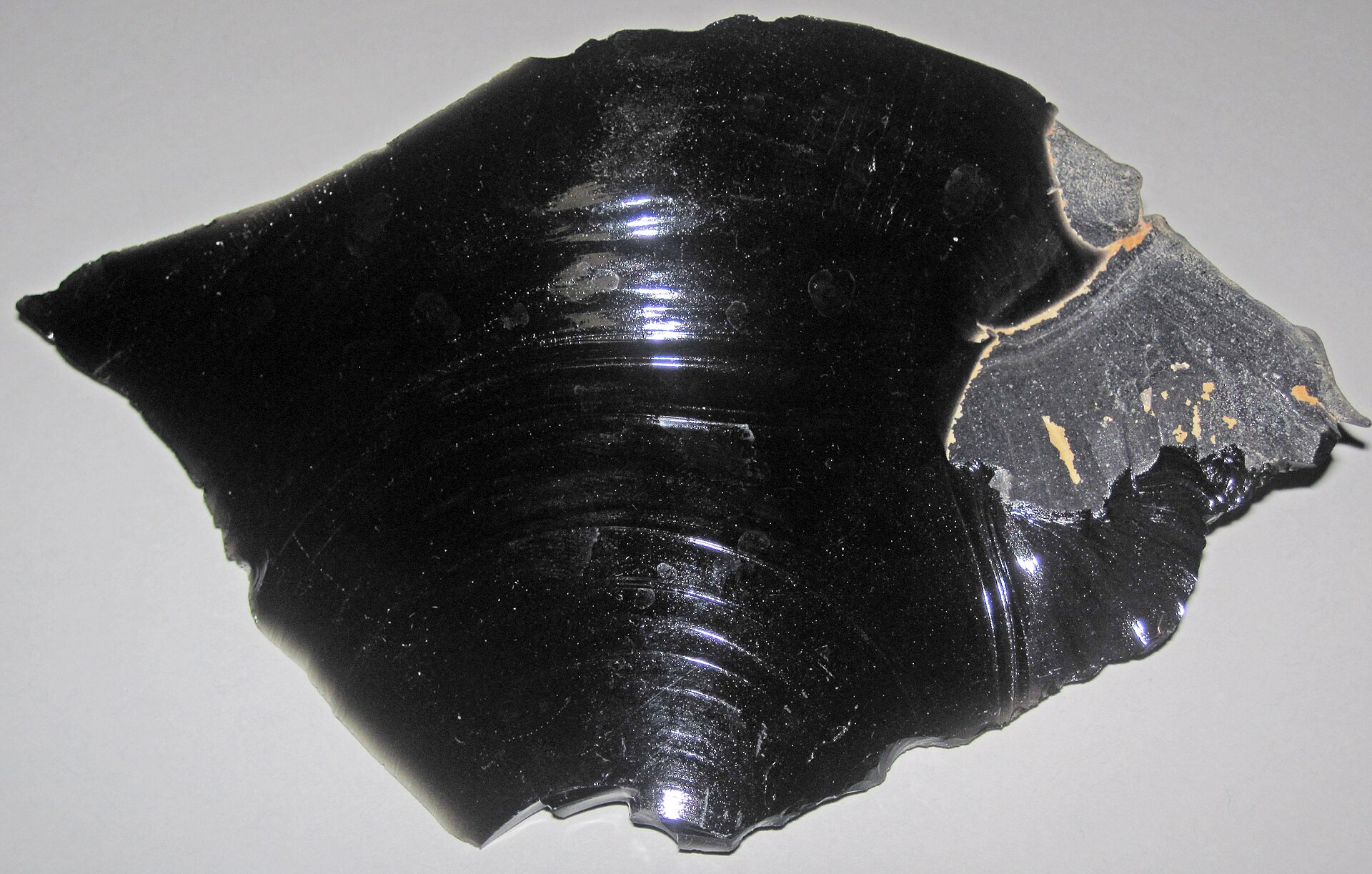 Obsidian mineral specimen — (~13.7 centimeters across at its widest) Igneous rocks form by the cooling & crystallization of hot,