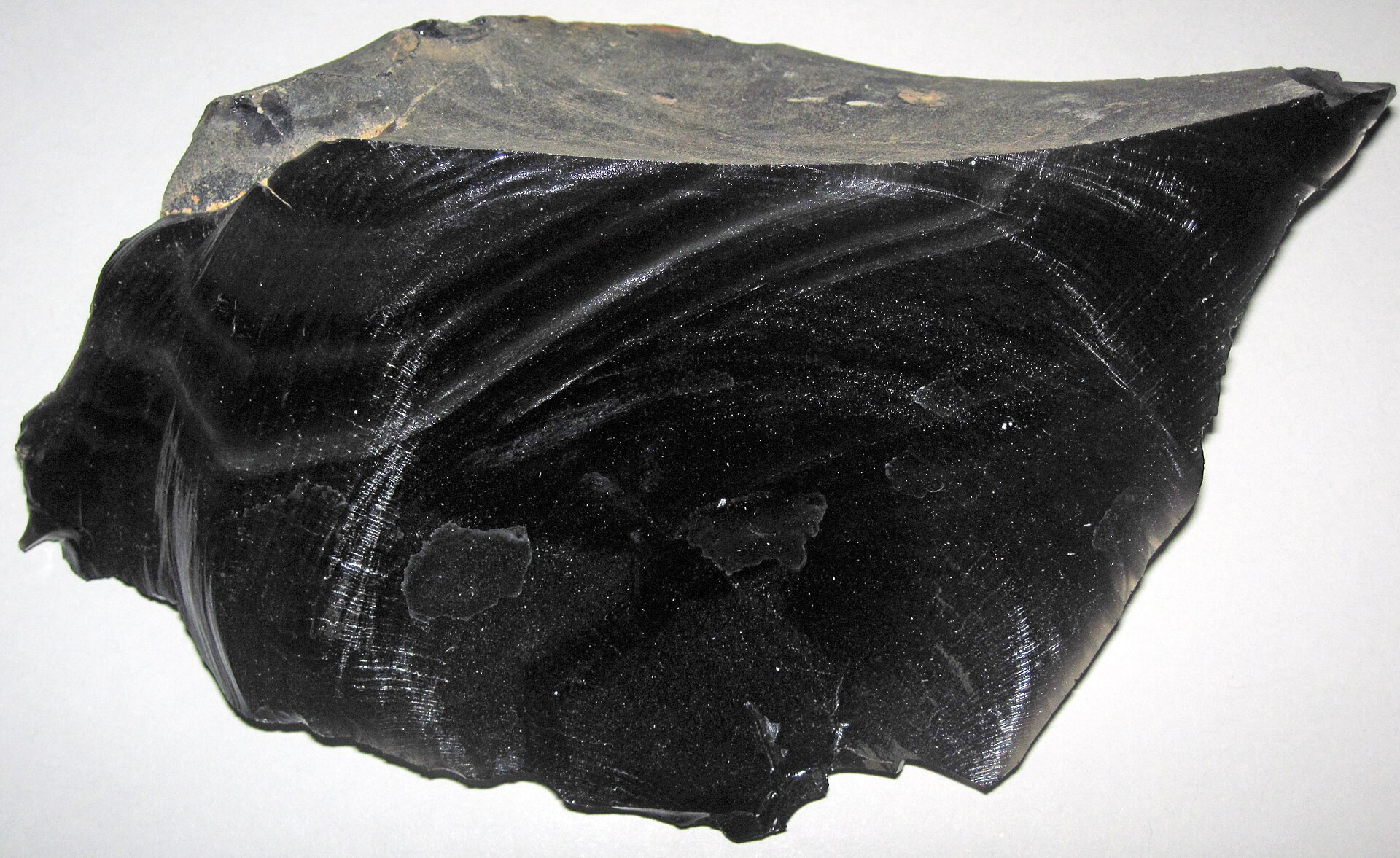 Obsidian mineral specimen — (~13.7 centimeters across at its widest) Igneous rocks form by the cooling & crystallization of hot,