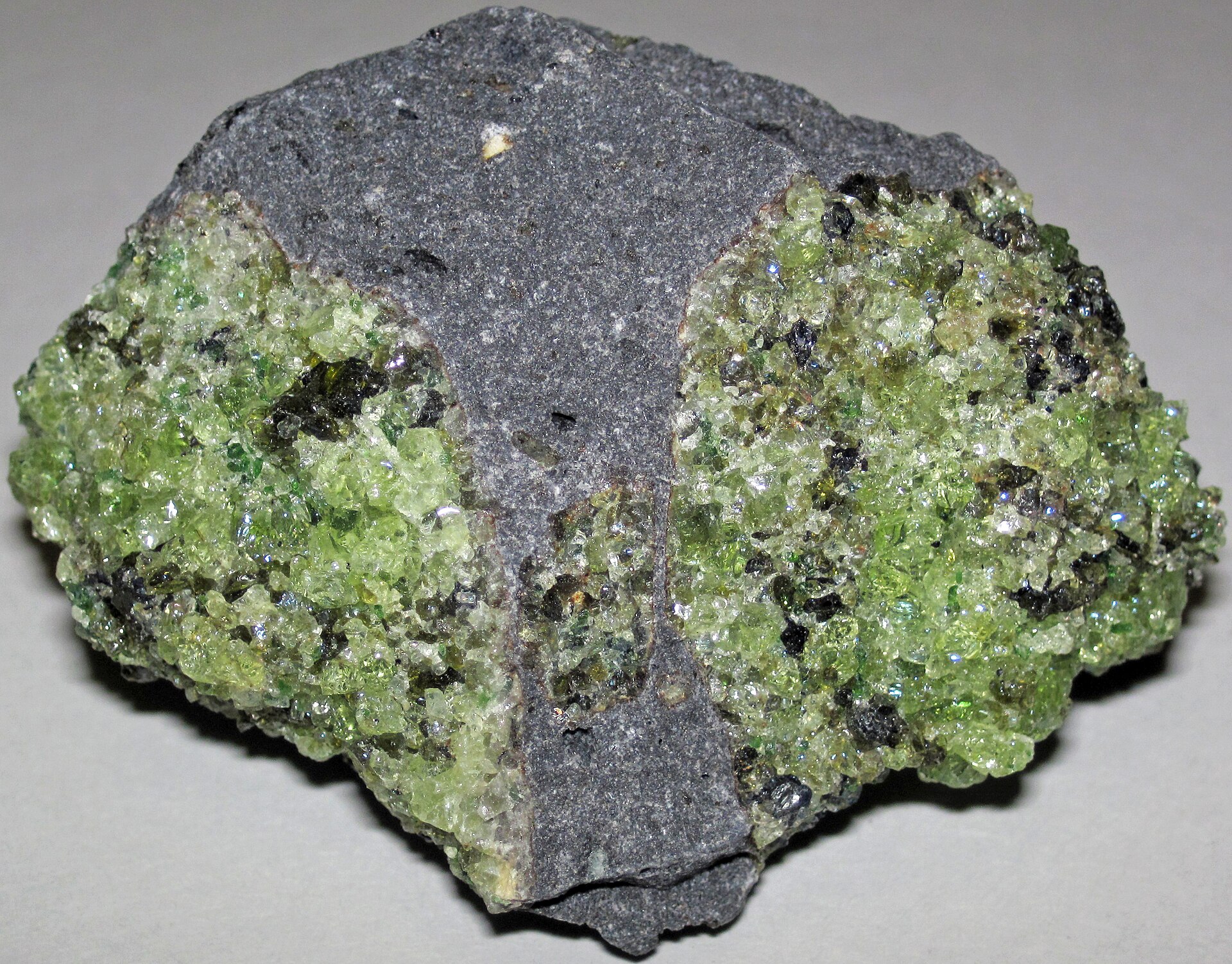 Peridot crystal mineral specimen — Peridotite mantle xenoliths in phonotephrite from the Pleistocene of Arizona, USA. Green = peridotit