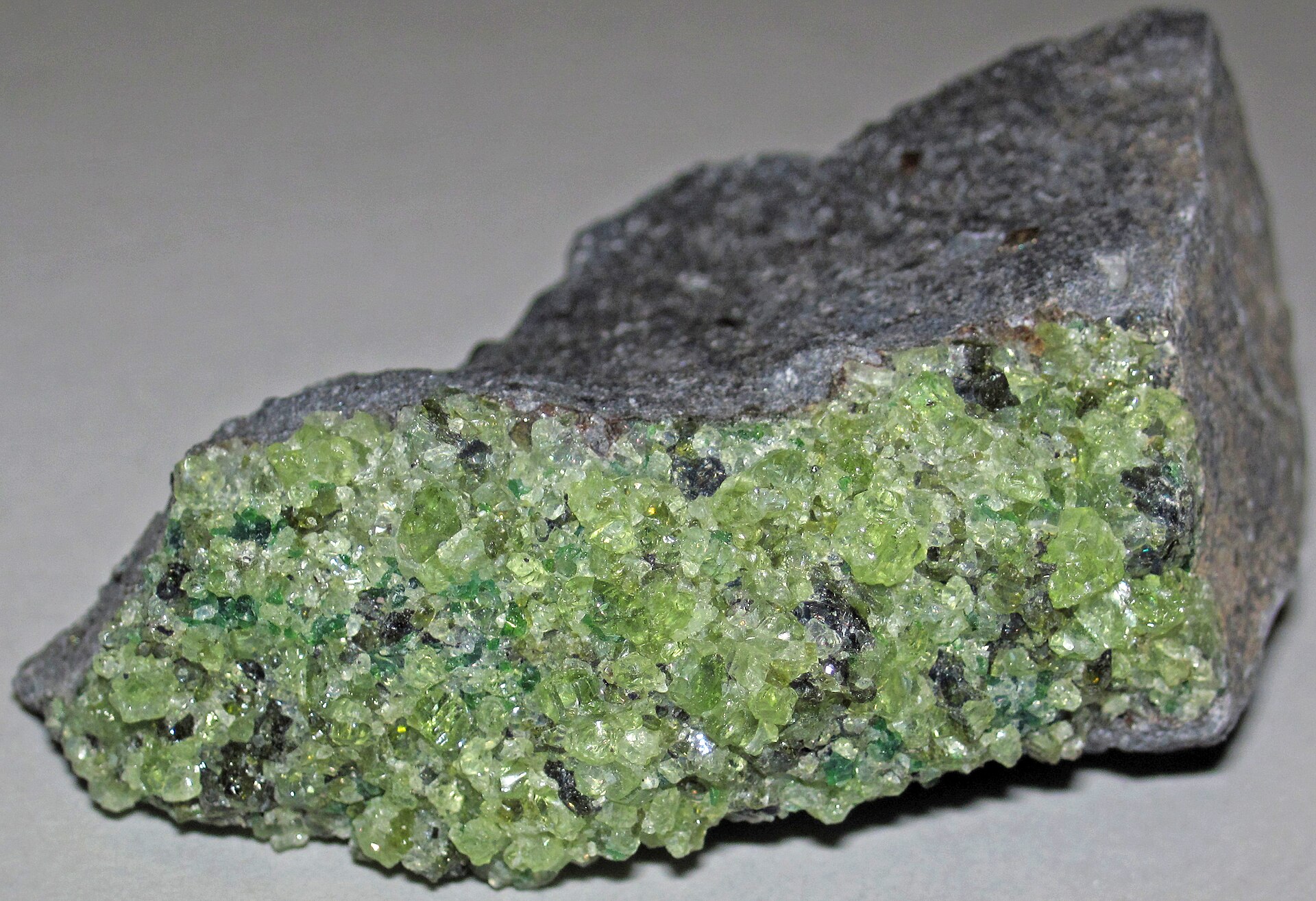 Peridot crystal mineral specimen — Peridotite mantle xenolith in phonotephrite from the Pleistocene of Arizona, USA. Green = peridotite