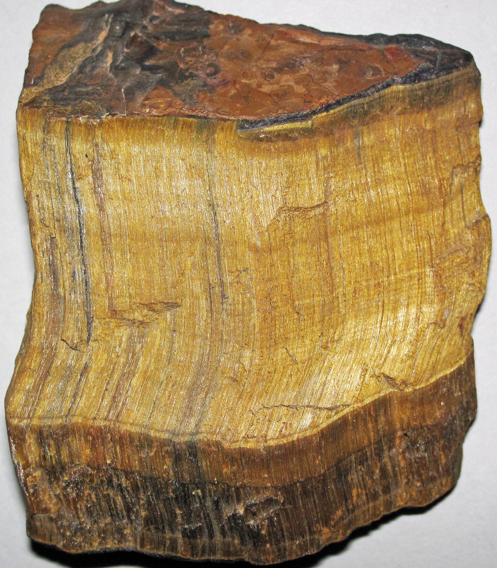 Tiger eye mineral specimen — Tiger's eye quartz (rough; ~5.0 centimeters across at its widest) A mineral is a naturally-occurring