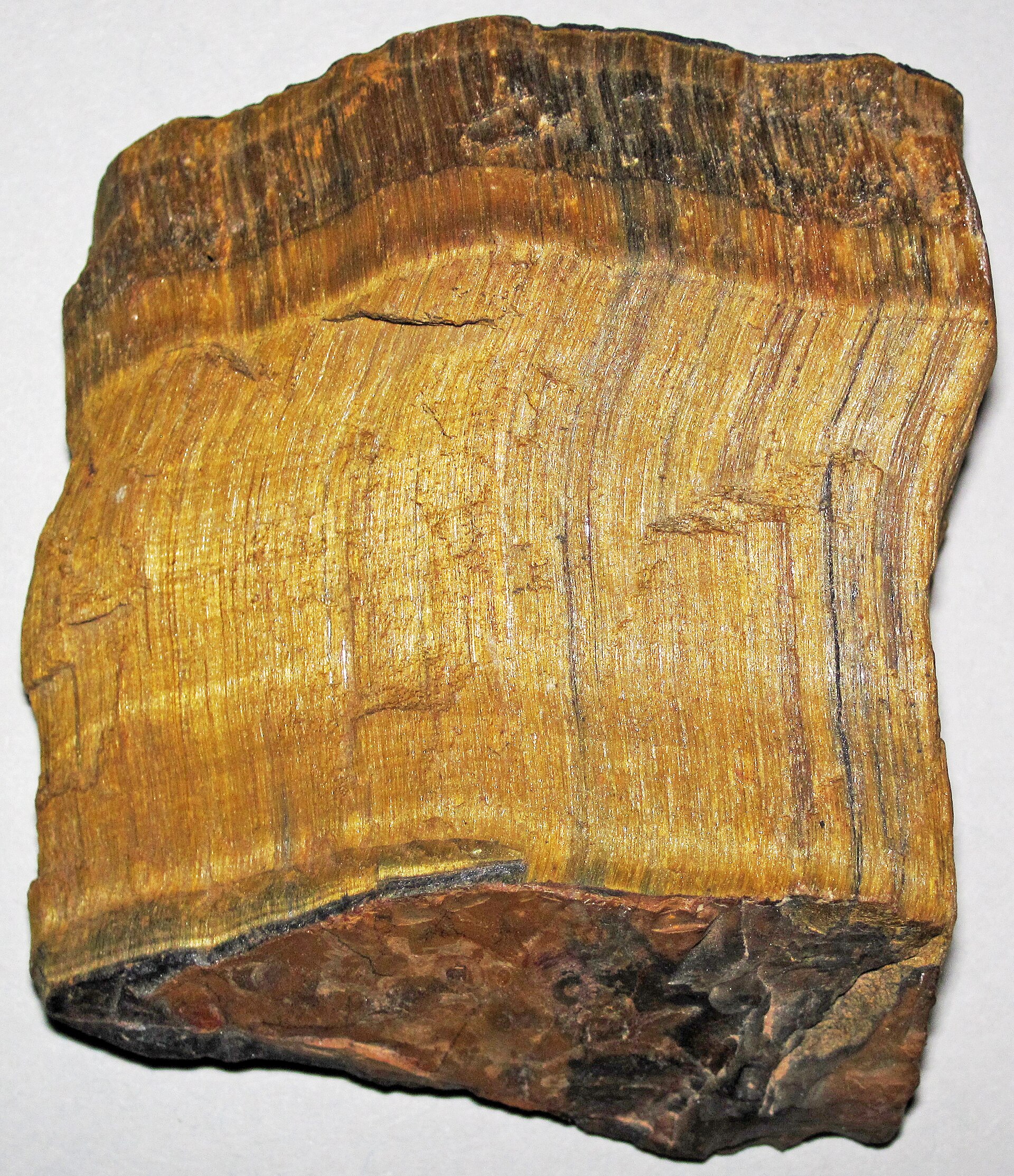Tiger eye mineral specimen — Tiger's eye quartz (rough; ~5.0 centimeters across at its widest) A mineral is a naturally-occurring