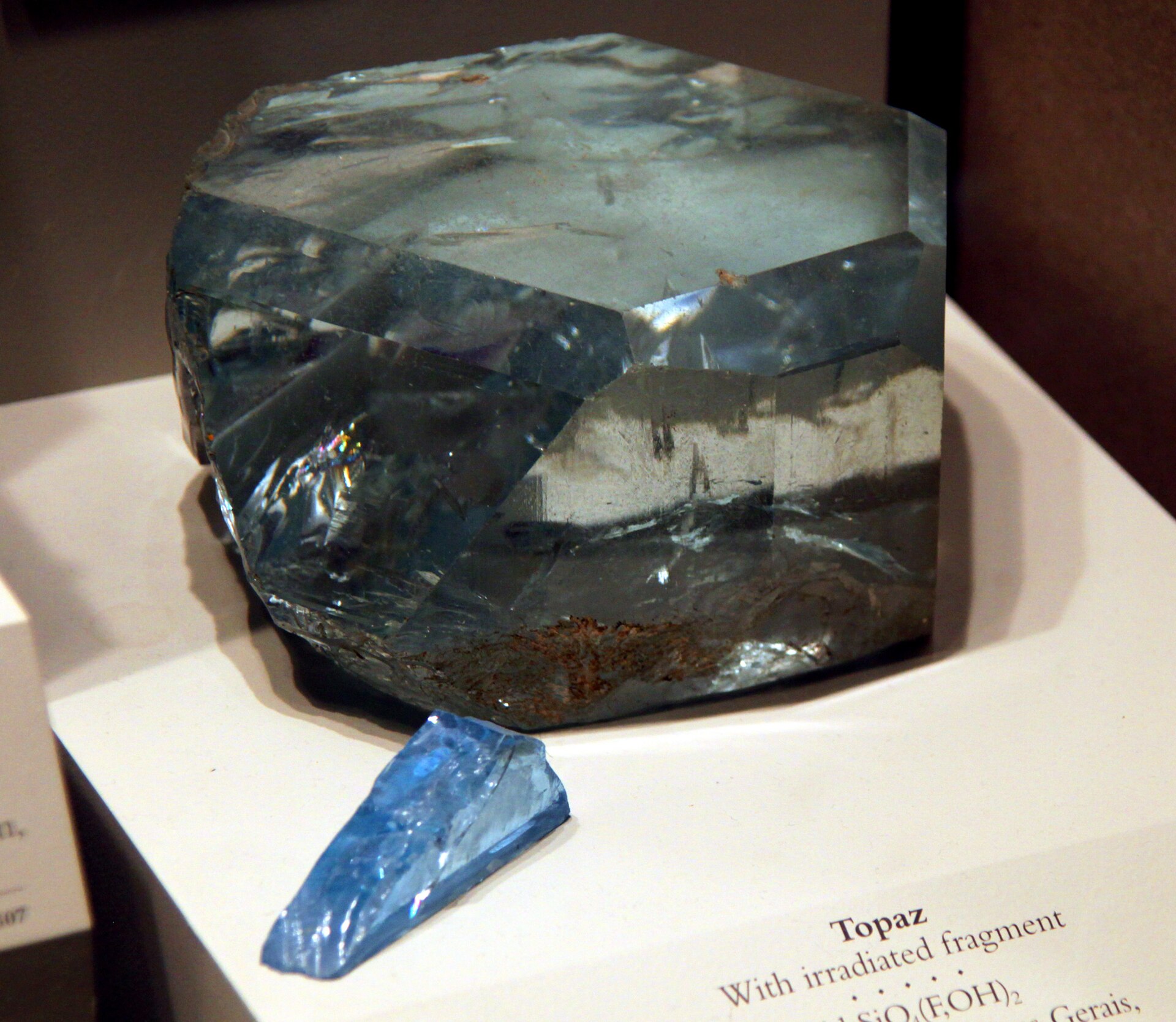 Topaz crystal mineral specimen — A large block of topaz and a small sample of irradiated topaz (in bright blue) on display in the Hal
